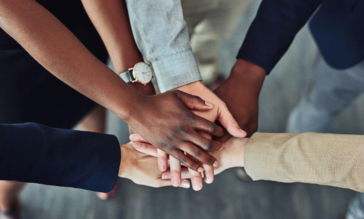 a group of people putting their hands together